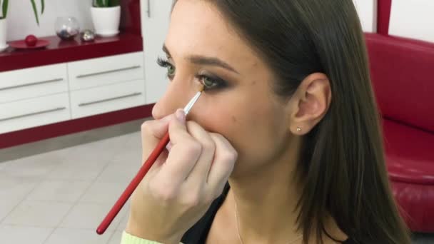 Schönheits- und Make-up-Konzept - Porträt einer schönen Frau, die sich professionell mit Pinsel schminkt — Stockvideo