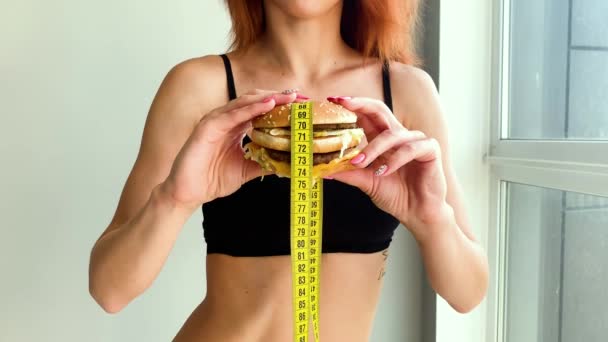 Dieta. Retrato de una mujer quiere comer una hamburguesa, pero una boca pegada, una noción de dieta, comida poco saludable, una voluntad en la nutrición — Vídeos de Stock