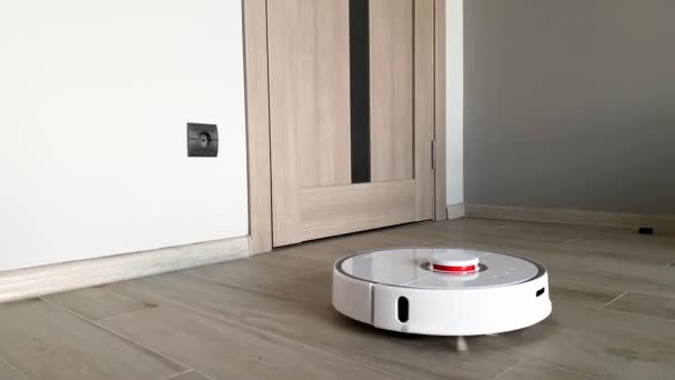 Casa Inteligente. Aspirador robot funciona en el suelo de madera en una sala de estar — Vídeos de Stock