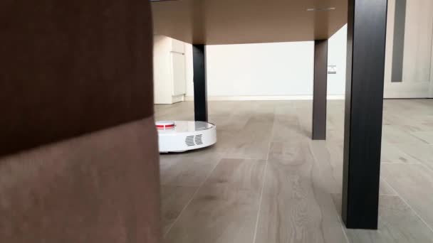 Умный дом. Пылесос робот работает на деревянном полу в гостиной — стоковое видео