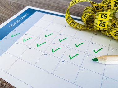 Diyet planı kavramı. Ahşap arka planda bant ve diyet planının ölçülmesi