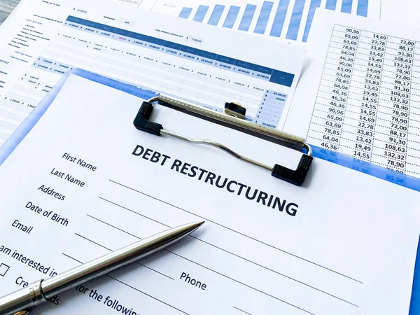 Документ о реструктуризации долга с таблицей на столе . — стоковое фото