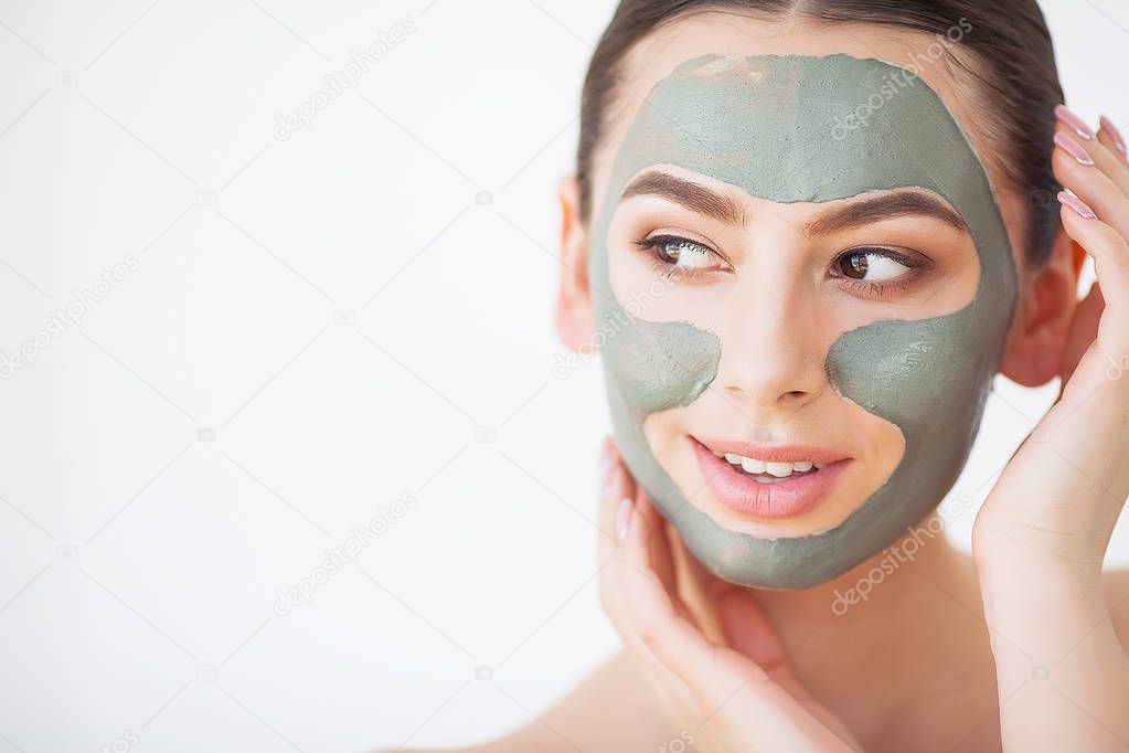 Skin Care. Young Woman With Cosmetic Clay Mask Holding Cucumber At Her Bathroom