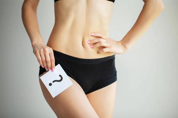 Salud. Mujer cuerpo en ropa interior con tarjeta de preguntas cerca del vientre —  Fotos de Stock