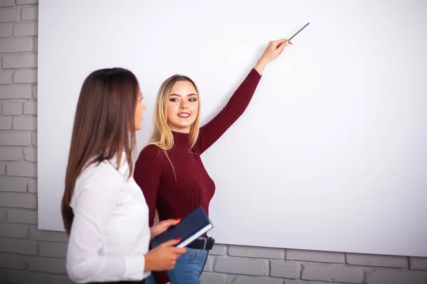 Duas colegas a trabalhar juntas. Duas colegas no escritório trabalhando juntas — Fotografia de Stock