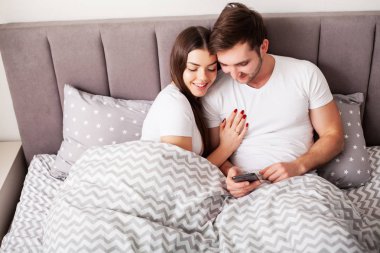 Genç çift selfie birlikte yatak odasında alarak gülümseyen