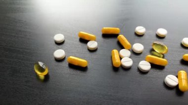 Tıbbi haplar. Siyah masa üzerinde renkli haplar ve kapsül. Eczane Tema, Paketlerde İlaç Antibiyotik ile Kapsül Pills