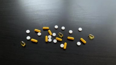 Tıbbi haplar. Siyah masa üzerinde renkli haplar ve kapsül. Eczane Tema, Paketlerde İlaç Antibiyotik ile Kapsül Pills