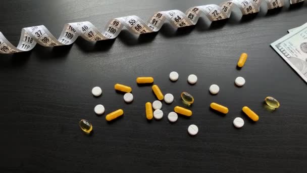 医療用薬黒いテーブルの上に着色された丸薬とカプセル。薬局のテーマ、パッケージに薬の抗生物質を含むカプセル錠剤 — ストック動画
