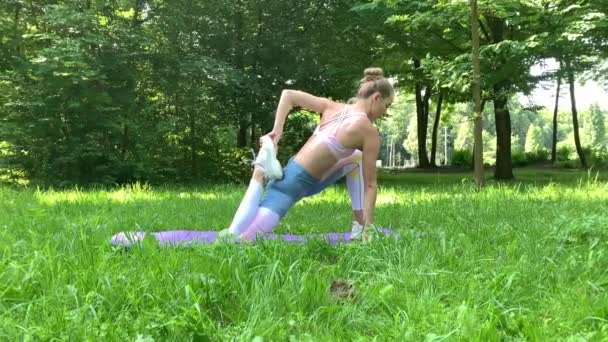 Fitness kvinna att göra övning på grön gräsmatta — Stockvideo