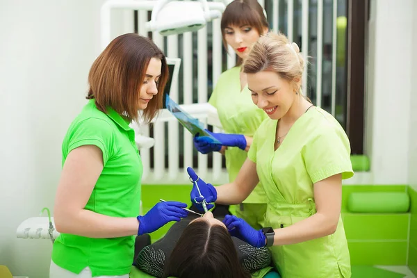 Tandartsen in tandheelkundige kantoor praten met vrouwelijke patiënt en voorbereiding voor behandeling — Stockfoto