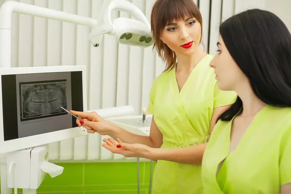 Zahnärzte in Zahnarztpraxis sprechen mit Patientin und bereiten sich auf Behandlung vor — Stockfoto
