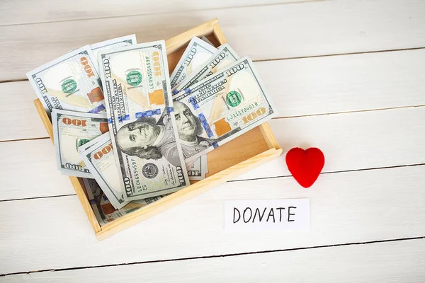 Donationer och välgörenhet. Donation-konceptet. Låda med donationer och hjärtat på den vita bakgrunden. — Stockfoto