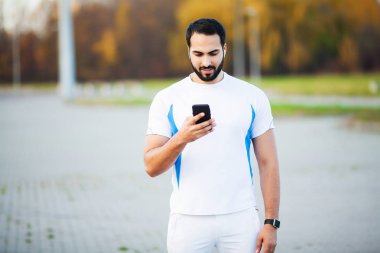 Adam şehir parkında çalışma ve cep telefonu kullanarak sonra