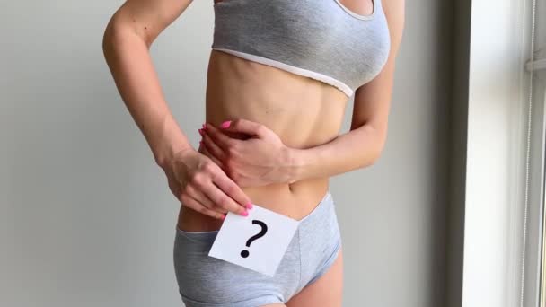 Salud. Mujer cuerpo en ropa interior con tarjeta de preguntas cerca del vientre . — Vídeos de Stock