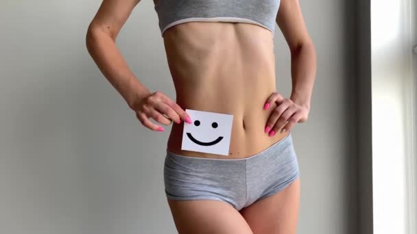 Salud de las mujeres. Primer plano de mujer sana con hermoso ajuste delgado cuerpo en bragas celebración de la tarjeta con la cara sonriente feliz en las manos. Salud estomacal y buenos conceptos de digestión . — Vídeos de Stock