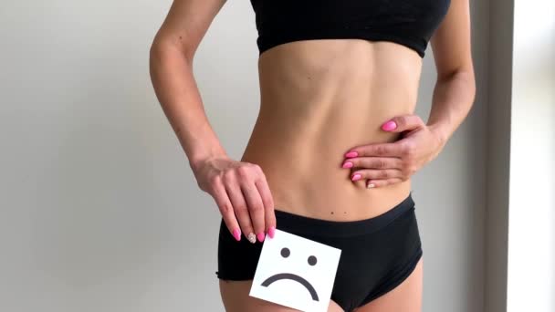 La santé des femmes. Femme corps tenant triste carte sourire près de l'estomac . — Video