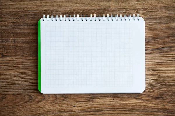 Ahşap masa üzerinde beyaz dizüstü bilgisayar üst görünümü.