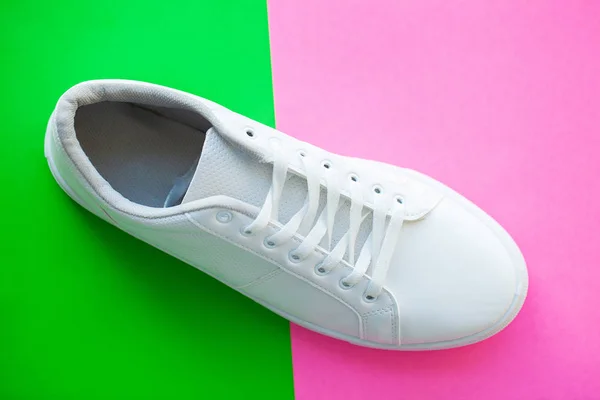 Par de nuevas zapatillas blancas con estilo sobre fondo rosa verde . — Foto de Stock