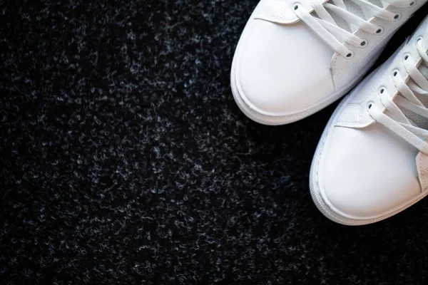Пара нових стильних білих кросівок на підлозі вдома . — стокове фото