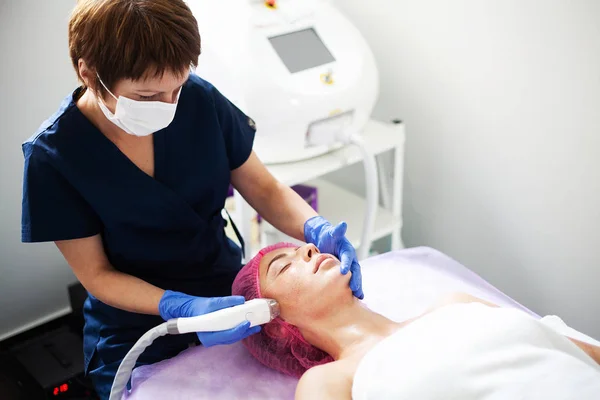 Mulher recebendo massagem de hardware GPL na clínica de beleza. Esteticista profissional trabalhando . — Fotografia de Stock