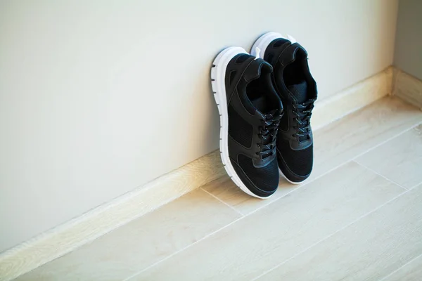 Пара новых стильных белых кроссовок на деревянном полу . — стоковое фото