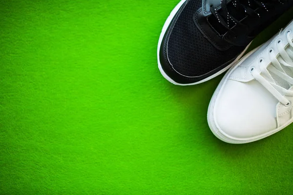 Par nya snygga sneakers på grön bakgrund. — Stockfoto