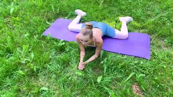 Mujer fitness haciendo ejercicio en césped verde . — Vídeos de Stock