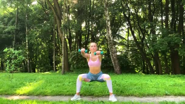 Fitness femme faisant de l'exercice sur la pelouse verte . — Video