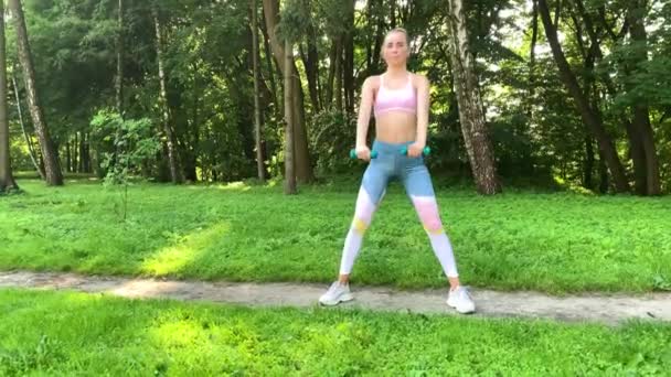 Fitness femme faisant de l'exercice sur la pelouse verte . — Video