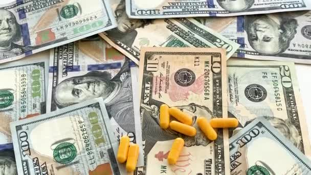 Medicina cara. Comprimidos de cores diferentes no fundo do dinheiro — Vídeo de Stock