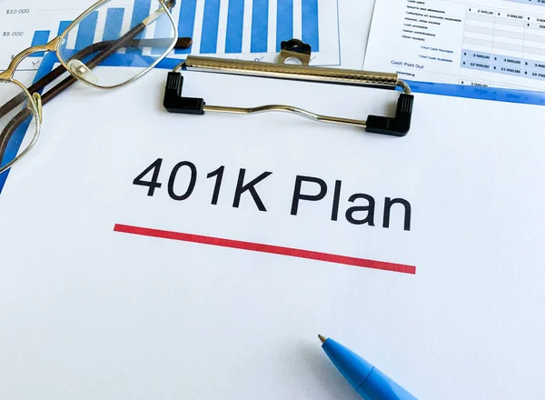 Paper with 401k plan on wood table.