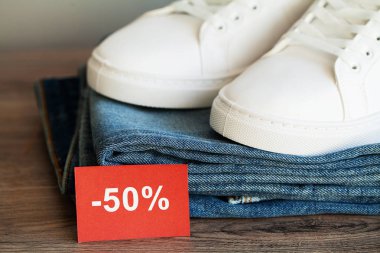 Mağaza rafında kot pantolon ve spor ayakkabılar.