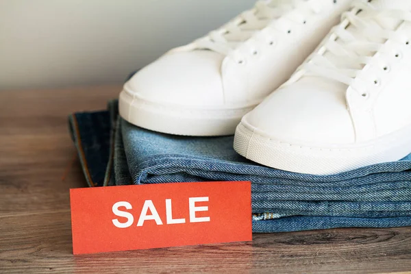 Jeans en sneakers op de plank van de winkel. — Stockfoto