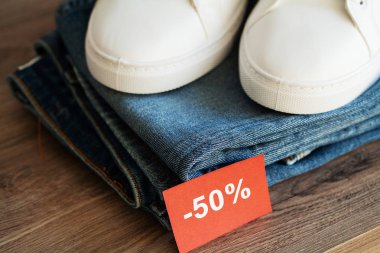 Mağaza rafında kot pantolon ve spor ayakkabılar.