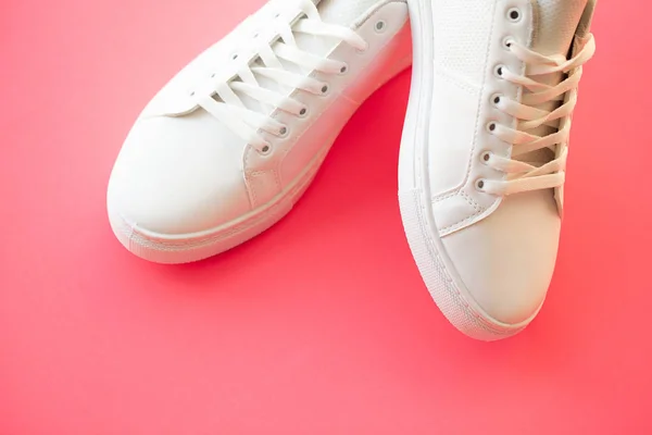 Стильные белые кроссовки на розовом фоне . — стоковое фото