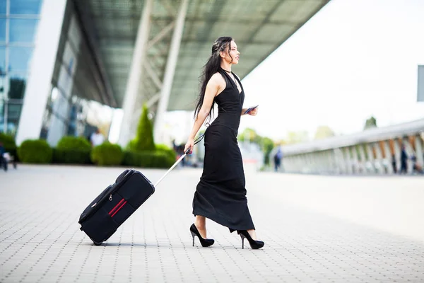 Νεαρή χαρούμενη γυναίκα με μια βαλίτσα. Η έννοια του ταξιδιού και της εργασίας — Φωτογραφία Αρχείου