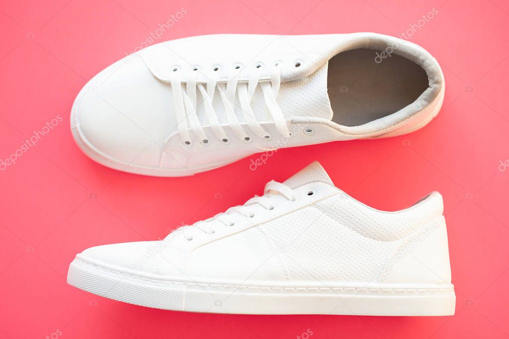 Stylish white fashion sneakers on pink background.
