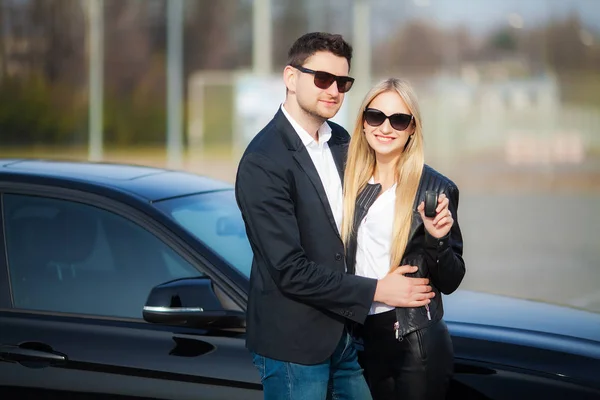 Pareja feliz comprar nuevo coche negro moderno —  Fotos de Stock