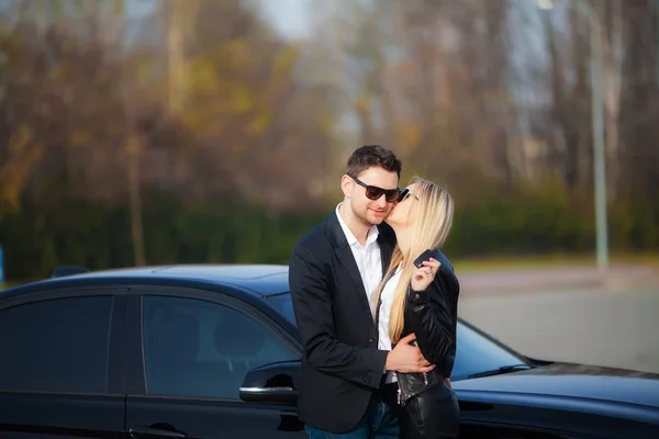 Lyckligt par köpa ny modern svart bil — Stockfoto