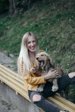 Köpek ile genç kız parkta yürür ve güzel yaz günü sahiptir.