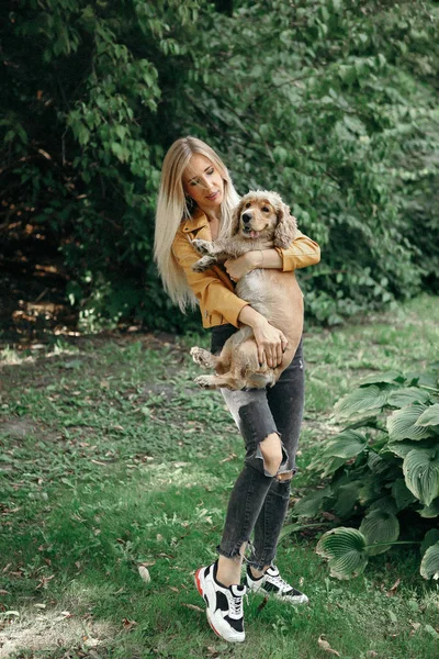 Köpek ile genç kız parkta yürür ve güzel yaz günü sahiptir. — Stok fotoğraf