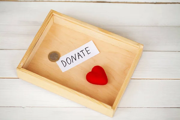 Spenden Sie! Box mit Geld auf weißem Holz Hintergrund — Stockfoto