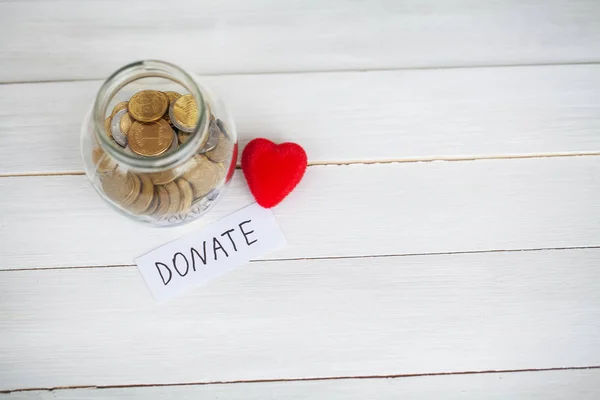 Spenden Sie! Glas mit Geld auf weißem Holz Hintergrund — Stockfoto