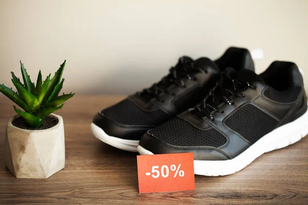 Coppia di nuove eleganti sneakers nere con sconto su sfondo grigio . — Foto Stock