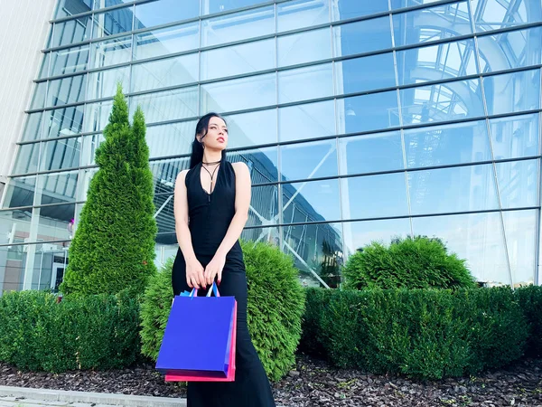 Día de compras. Mujer sosteniendo bolsas de colores cerca de su centro comercial de rodaje en vacaciones de viernes negro —  Fotos de Stock