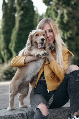 Köpek ile genç kız parkta yürür ve güzel yaz günü sahiptir.