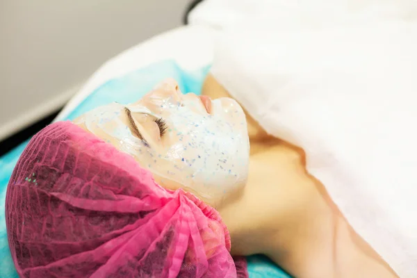 Wellnesstherapie für junge Frau mit Gesichtsmaske im Schönheitssalon. — Stockfoto
