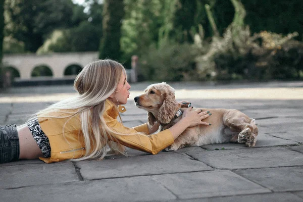 Köpek ile genç kız parkta yürür ve güzel yaz günü sahiptir.