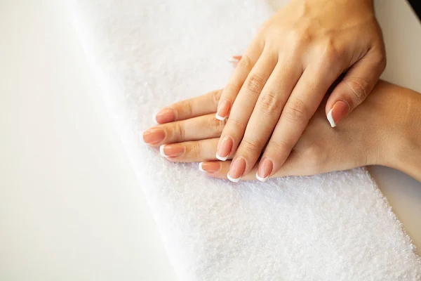 Belle unghie delle donne con manicure francese, in studio di bellezza — Foto Stock